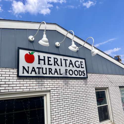 Smiling woman surrounded by plants eating a salad