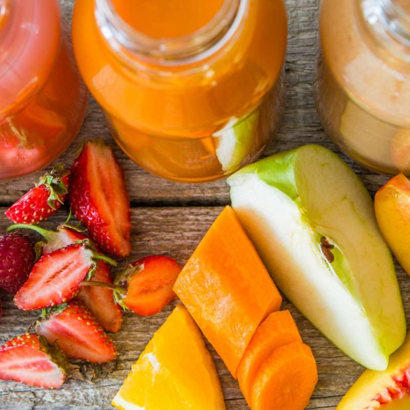 smoothies, fruits, and vegetables laid out on table